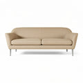 **Moderne beige bank met slanke metalen poten**